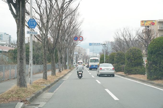 11左手にセブンイレブン（千里万博公園西口店）、右手にトマト＆オニオン（千里万博公園店）があります。